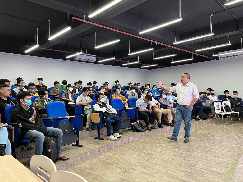 Nguyễn Chiến Trường đứng giảng trong giảng đường đông sinh viên, phía sau là bảng trắng.